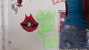 Ebony woman with big tits performs deepthroat on interracial cock through glory hole, then bent over in doggystyle for hardcore fucking.