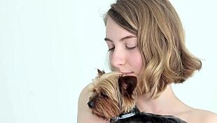 hot naked blonde cuddles her puppy in a tender moment