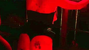 Behind the scenes: blonde girl in handcuffs receives wax drops.