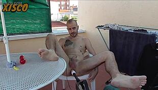 xisco gets naked outdoors, using a machine to fuck himself while neighbors watch.