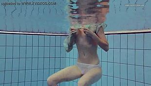 Nastya volna swims gracefully in the pool underwater