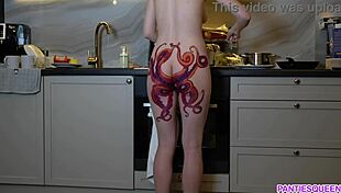 naked housewife with tattoo cooks dinner in kitchen, ignoring distractions