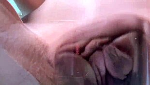 Petite teen rubs her shaved pussy on the glass table close up.