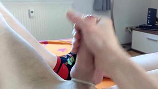 Young German guy watches gay porn and gets a handjob cumshot