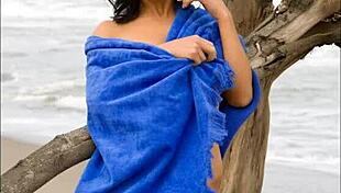 Modelz beauty relaxes in the sand, enjoying the peaceful view