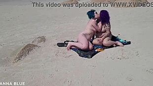 Two lesbians naked on the beach kissing passionately.