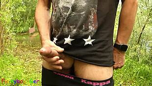 Gay guy boldly jerks off by the lake, fingering his tight hole intensely.