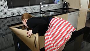 Redhead searches for keys, revealing downblouse view in kitchen