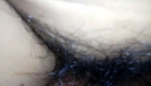 My wife lies with legs spread apart, revealing her bushy, hairy vagina for close inspection