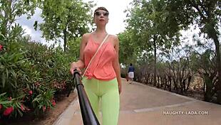 Camel-toe flashing in public with milf showing off tits and leggings in outdoor nude scene.