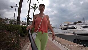 Camel-toe flashing in public with milf showing off tits and leggings in outdoor nude scene.