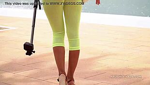 Camel-toe flashing in public with milf showing off tits and leggings in outdoor nude scene.