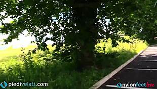 Brunette Woman Displays Her Feet In Black Pantyhose From Car Window