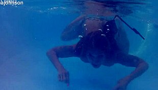 Melissa the mermaid swims in the pool with tattoos and brown eyes