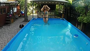 Melissa the mermaid swims in the pool with tattoos and brown eyes