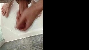 A muscular blonde bodybuilder with blue eyes showers her cock in the bath
