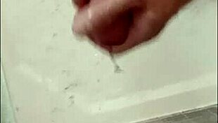 A muscular blonde bodybuilder with blue eyes showers her cock in the bath