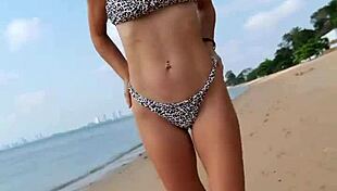 Petite girl waits on the beach in summer bikini