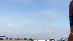 African woman flashes on beach.