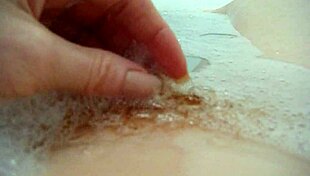 annie relaxes in the bath, fingering her hairy pussy