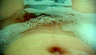 annie relaxes in the bath, fingering her hairy pussy