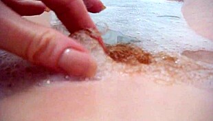 annie relaxes in the bath, fingering her hairy pussy