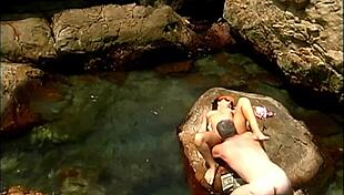 a mature man fucks an exotic babe in a cap and sunglasses on the seaside stones