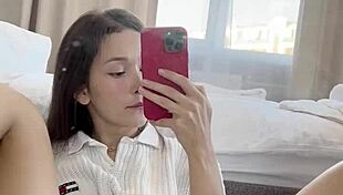 Ellie Leen fingers her hairless shaved pussy in front of the mirror