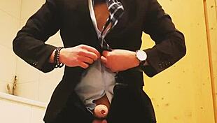 guy strokes his cock hard in tight business suit on bed