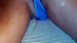 Slipping into bed wearing blue lingerie, she starts fingering her beautiful ebony curves gently