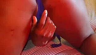Slipping into bed wearing blue lingerie, she starts fingering her beautiful ebony curves gently