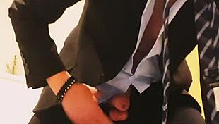 guy strokes his cock hard in tight business suit on bed