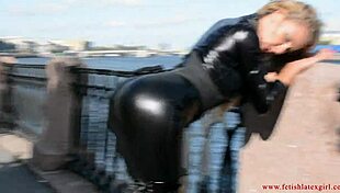 Latex-clad mona struts sexy suit and heels down street flaunting tight curves