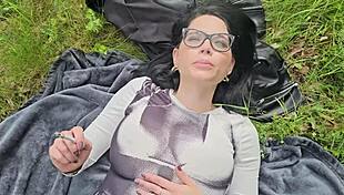 She smokes on the grass baring her huge natural tits in sunlight