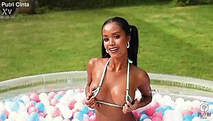 putri cinta splashes playfully in paddling pool footage