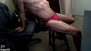 bodybuilder grinds muscular legs on stool in red briefs stretchin pain away