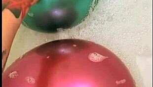 Tattooed girl teases balloons in steamy bath play
