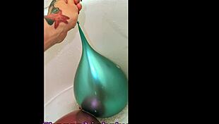 Tattooed girl teases balloons in steamy bath play