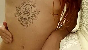 Redhead teen 18+ relaxes tattooed in steamy bath